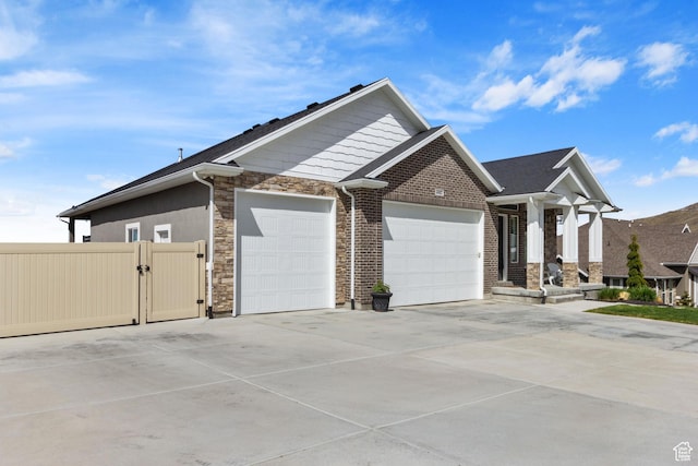 6982 W Majestic View Ln S, Herriman, UT 84096 - view of front of home featuring a garage, driveway, stone siding, and a gate