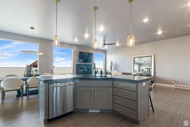 6982 W Majestic View Ln S, Herriman, UT 84096 - kitchen with stainless steel dishwasher, a sink, dark wood finished floors, dark countertops, and gray cabinetry