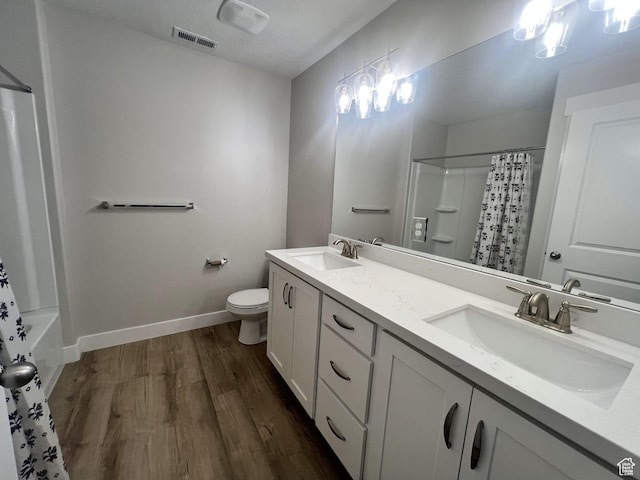 full bathroom with visible vents, wood finished floors, toilet, and a sink