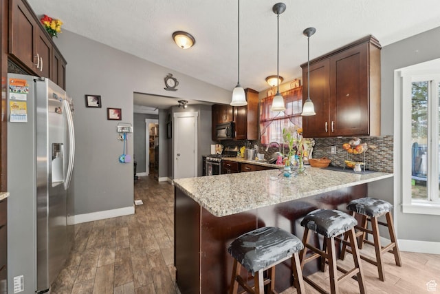 kitchen with baseboards, appliances with stainless steel finishes, tasteful backsplash, and a wealth of natural light