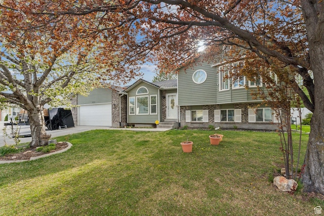 tri-level home featuring an attached garage, a front yard, and driveway