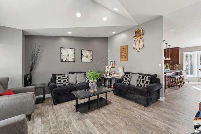 living area with baseboards, lofted ceiling, light wood-style floors, and recessed lighting