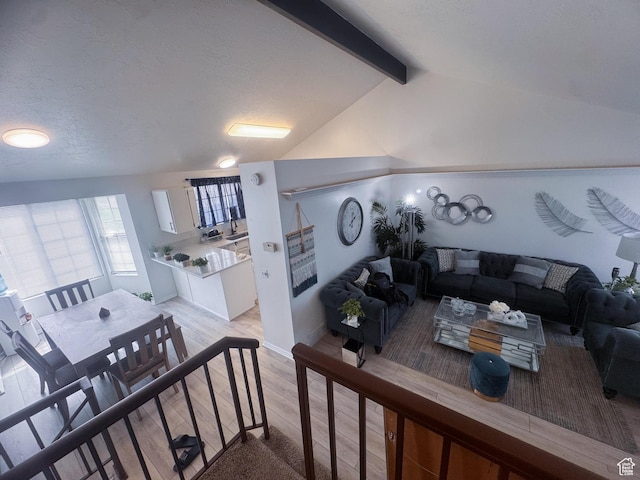 1689 W Crystal Ridge Dr S, West Jordan, UT 84084 - living area with light wood-style floors, baseboards, and lofted ceiling with beams