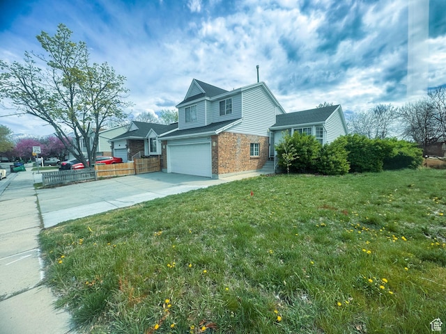 view of side of property featuring driveway, fence, brick siding, an attached garage, and a yard