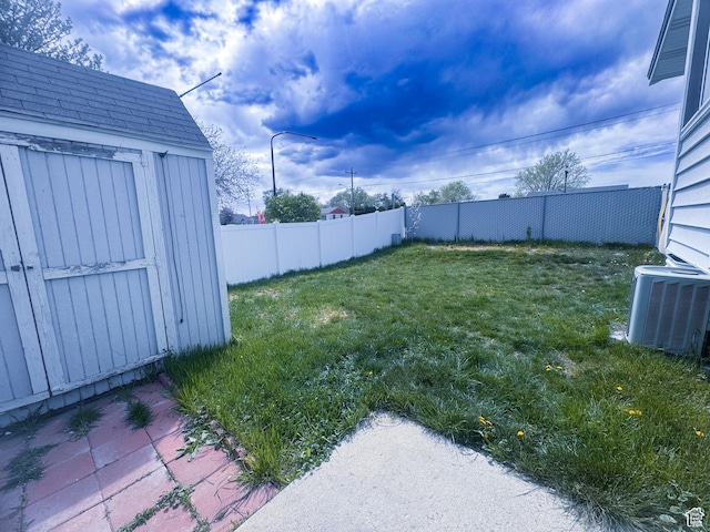 1689 W Crystal Ridge Dr S, West Jordan, UT 84084 - view of yard featuring central air condition unit, an outdoor structure, a storage unit, and a fenced backyard