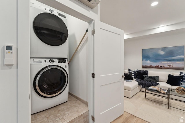 laundry area with stacked washer / dryer, light wood finished floors, and recessed lighting