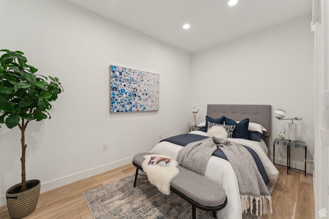 bedroom with recessed lighting, light wood finished floors, and baseboards