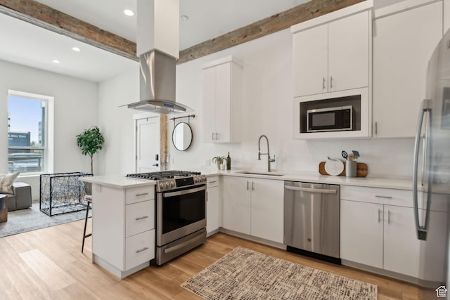 kitchen featuring stainless steel appliances, beam ceiling, a sink, a peninsula, and light countertops