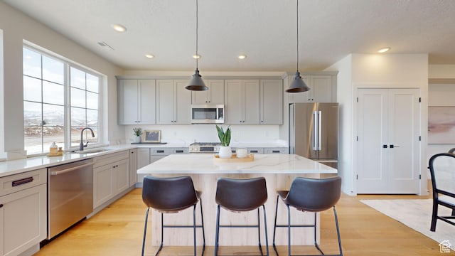 1822 S 930 E Unit 541, Heber City, UT 84032 - kitchen featuring stainless steel appliances, a breakfast bar, a sink, a kitchen island, and a wealth of natural light