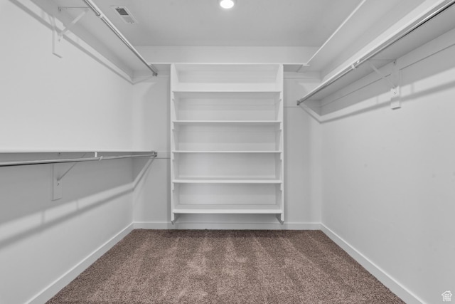 spacious closet with dark colored carpet and visible vents
