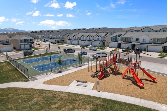 exterior space featuring a tennis court, a residential view, fence, and playground community