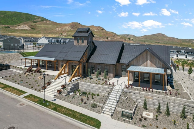 exterior space with stairway, a standing seam roof, a mountain view, and metal roof
