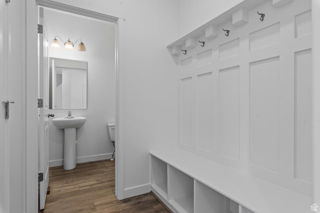 mudroom with baseboards, dark wood-type flooring, and a sink