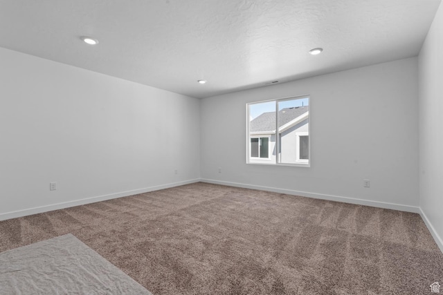 carpeted spare room featuring baseboards and recessed lighting