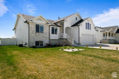 1065 W 275 S, Tremonton, UT 84337 - view of front of house with concrete driveway, a front lawn, stone siding, and a garage