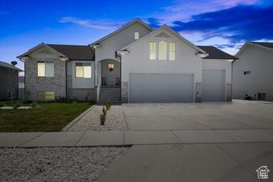 1065 W 275 S, Tremonton, UT 84337 - split level home with concrete driveway, an attached garage, and stone siding
