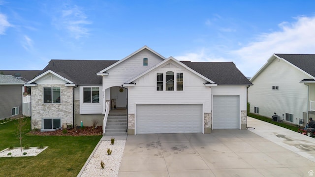 view of front of home featuring central air condition unit, driveway, stone siding, and a front lawn