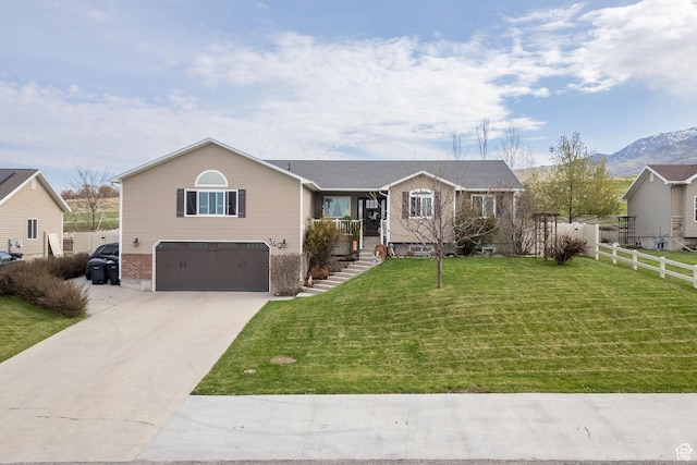 ranch-style house with a front lawn, driveway, fence, a mountain view, and a garage