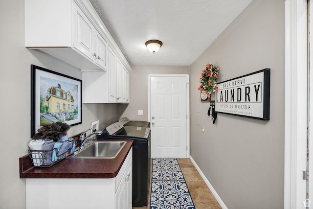 laundry room with light tile patterned floors, a sink, baseboards, separate washer and dryer, and cabinet space