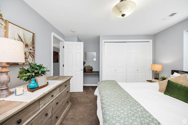 bedroom featuring dark colored carpet, visible vents, and a closet
