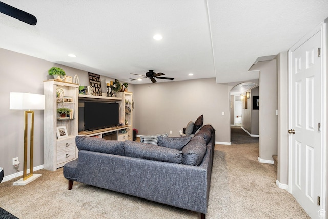 carpeted living area with a ceiling fan, baseboards, arched walkways, and recessed lighting