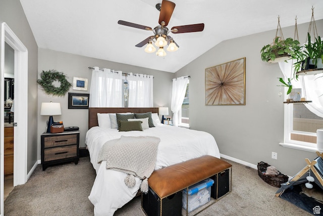 carpeted bedroom featuring vaulted ceiling, baseboards, and ceiling fan