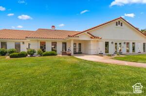 150 S Crystal Lakes Dr Unit 51, St George, UT 84770 - back of property with a chimney, a tile roof, and a yard