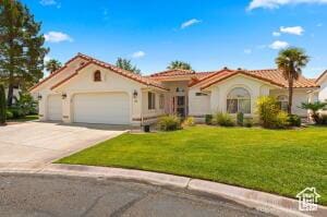 150 S Crystal Lakes Dr Unit 51, St George, UT 84770 - mediterranean / spanish house featuring a front yard, stucco siding, driveway, and an attached garage