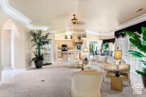 150 S Crystal Lakes Dr Unit 51, St George, UT 84770 - living room with carpet flooring, ornamental molding, and arched walkways