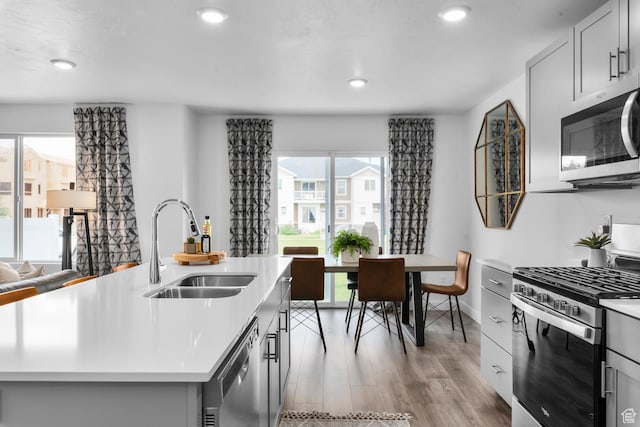 3814 S Landmark Ln Unit 1395, Magna, UT 84044 - kitchen featuring a sink, light wood-type flooring, light countertops, appliances with stainless steel finishes, and recessed lighting