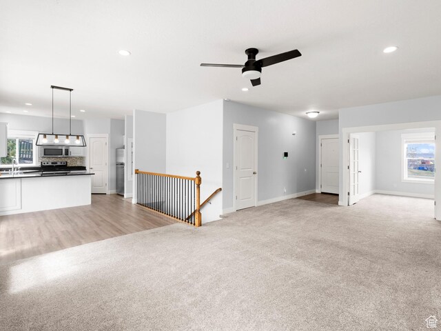 361 W Bridle Cir, Saratoga Springs, UT 84045 - unfurnished living room featuring a ceiling fan, a sink, light colored carpet, baseboards, and recessed lighting