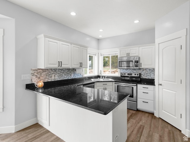 361 W Bridle Cir, Saratoga Springs, UT 84045 - kitchen featuring a peninsula, appliances with stainless steel finishes, a sink, and white cabinetry