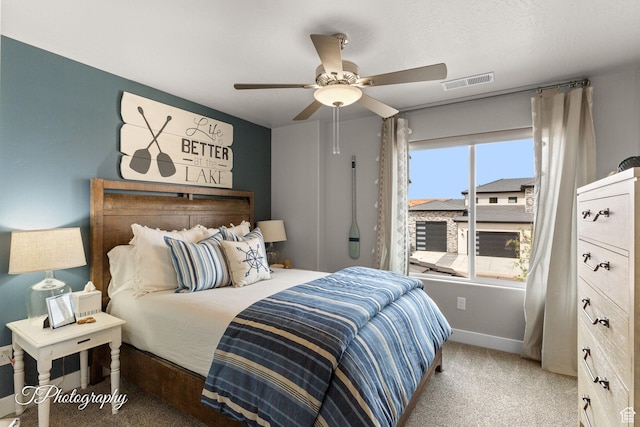 carpeted bedroom featuring baseboards, visible vents, and ceiling fan
