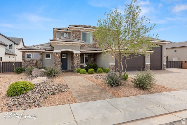 prairie-style house with stone siding, stucco siding, and decorative driveway