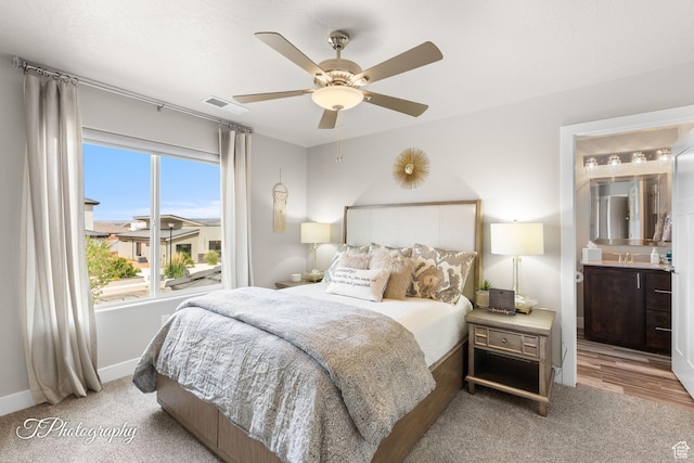 bedroom with ensuite bathroom, baseboards, visible vents, ceiling fan, and carpet floors