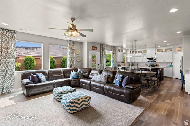 living area with a ceiling fan, visible vents, dark wood-style floors, and recessed lighting