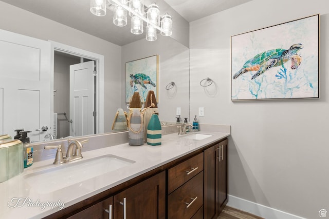 full bathroom with baseboards, a sink, and double vanity