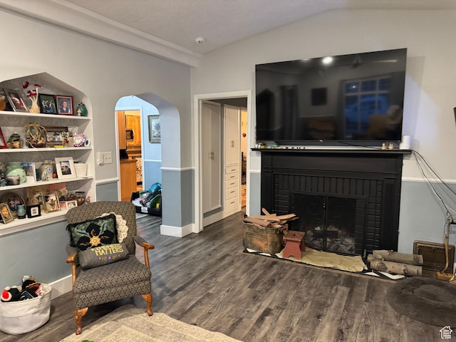 117 S 7th St, Montpelier, ID 83254 - living area featuring arched walkways, wood finished floors, a brick fireplace, lofted ceiling, and baseboards