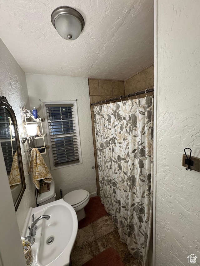117 S 7th St, Montpelier, ID 83254 - full bathroom with a textured wall, a textured ceiling, a sink, toilet, and a shower with shower curtain