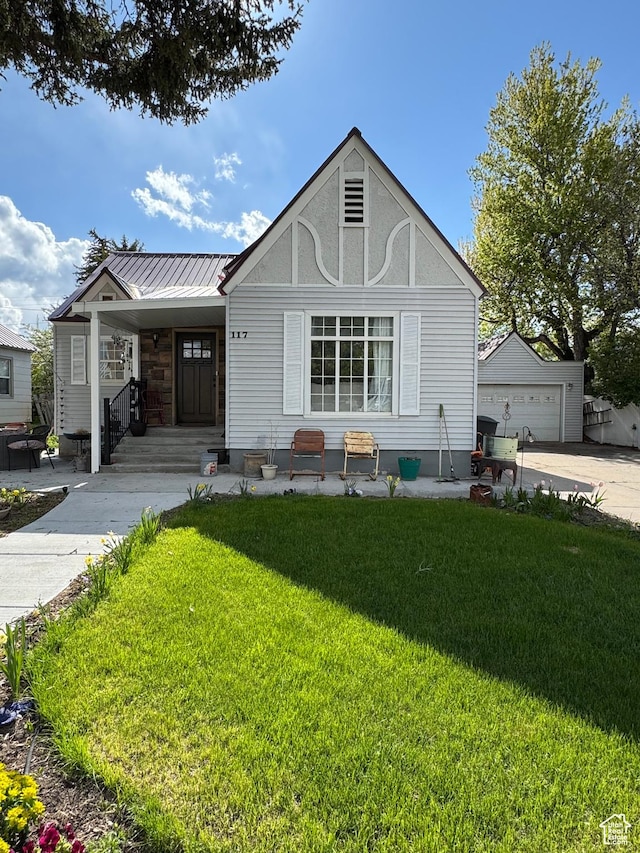 117 S 7th St, Montpelier, ID 83254 - english style home with a front yard, concrete driveway, and metal roof