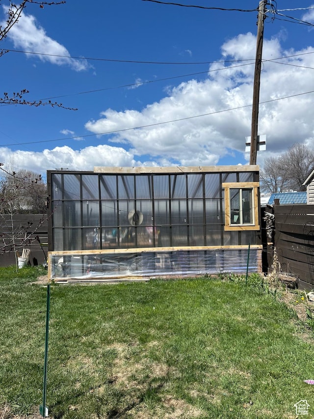 117 S 7th St, Montpelier, ID 83254 - back of house with a greenhouse, a yard, and an outbuilding