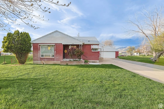 view of front of house featuring an outdoor structure, brick siding, a front yard, and a detached garage