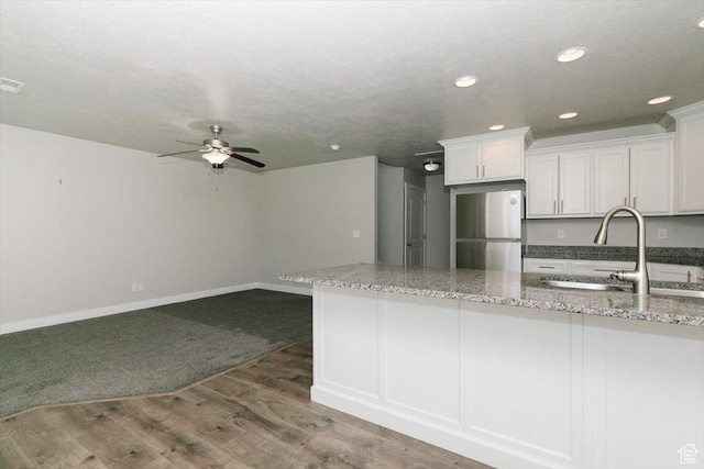 162 E 2480 N, North Logan, UT 84341 - kitchen with freestanding refrigerator, a sink, white cabinetry, a ceiling fan, and light wood finished floors