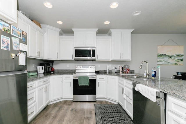 162 E 2480 N, North Logan, UT 84341 - kitchen with stainless steel appliances, a sink, light wood-type flooring, light stone countertops, and white cabinetry