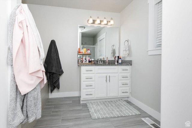 162 E 2480 N, North Logan, UT 84341 - bathroom with wood finished floors, visible vents, vanity, baseboards, and walk in shower