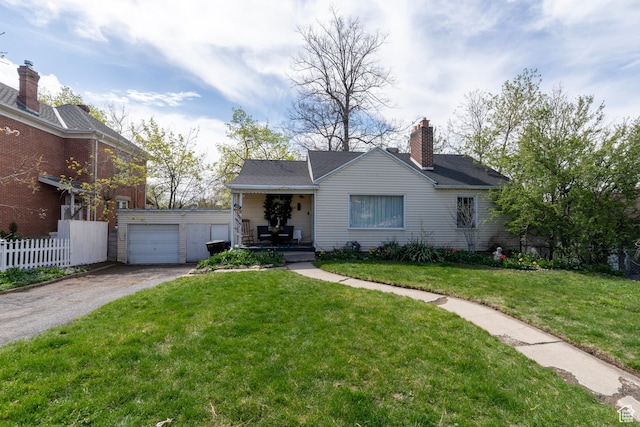 view of front of home featuring fence, an outdoor structure, covered porch, a front yard, and a garage