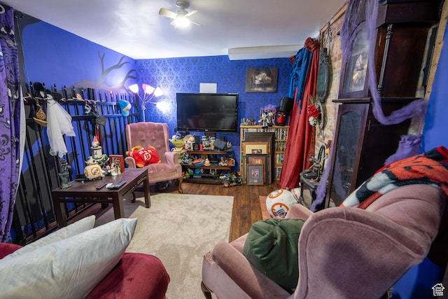 living room with wallpapered walls, wood finished floors, and ceiling fan