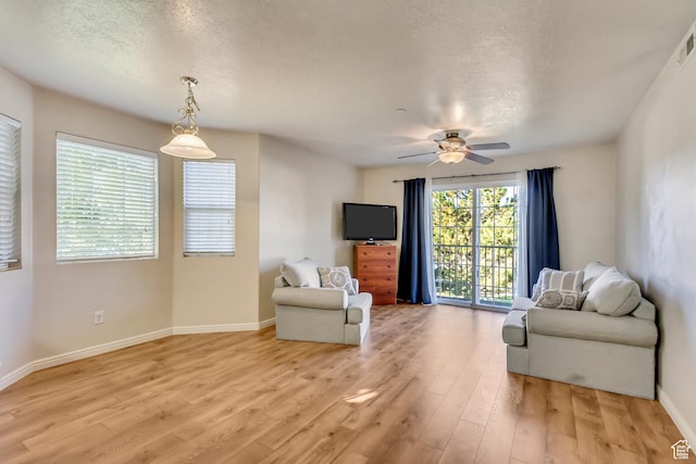 2093 N Morning Star Dr, Saratoga Springs, UT 84045 - living area featuring a textured ceiling, light wood-type flooring, baseboards, visible vents, and ceiling fan