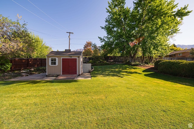 view of yard featuring an outbuilding, a fenced backyard, and a shed