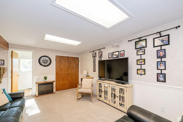 living room featuring carpet, a fireplace, and wainscoting